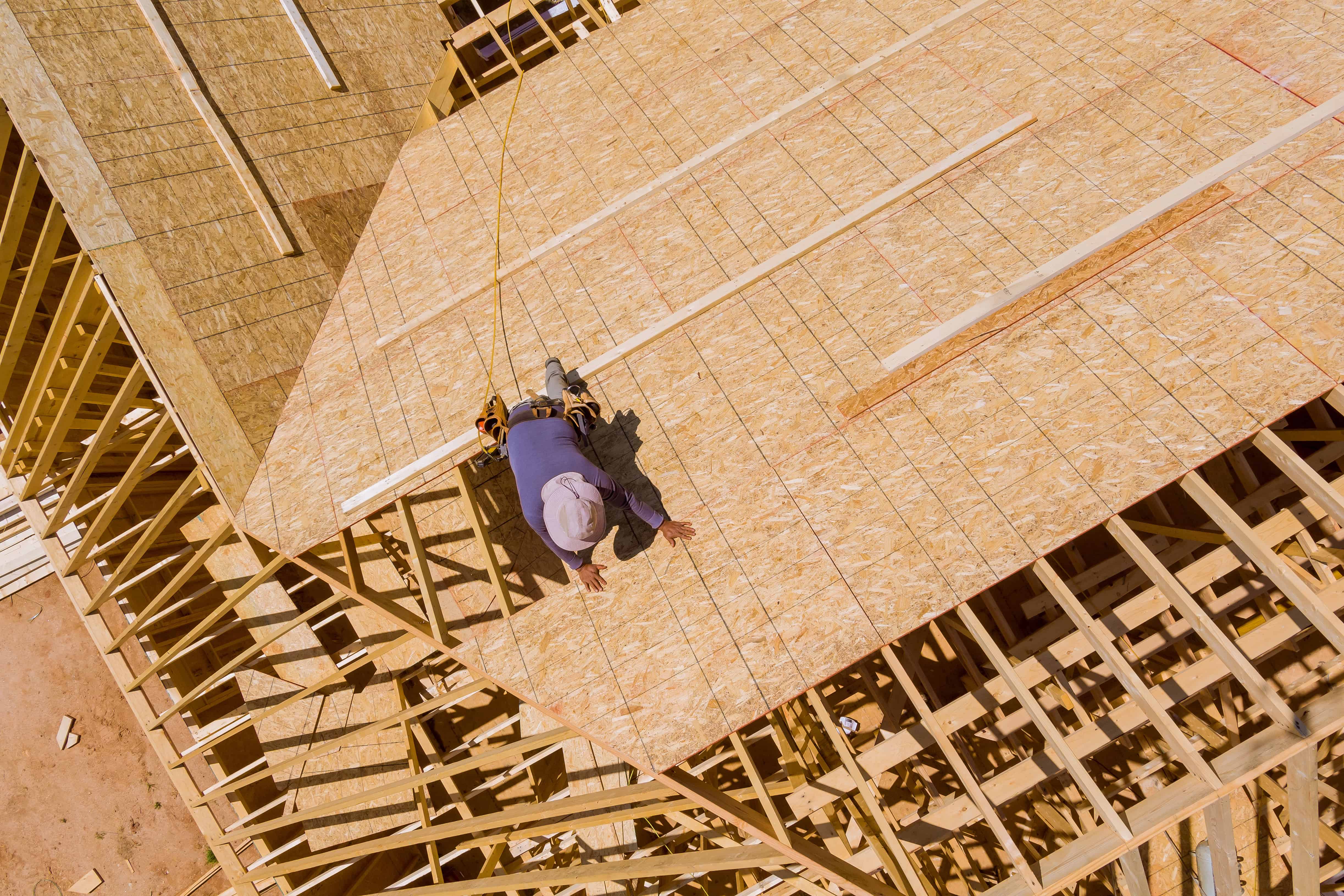Travailleur sur charpente de toit en construction